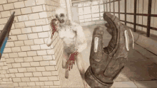 a video game with a hand holding a gun and a zombie