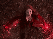a woman in a red jacket is casting a spell with her hands .