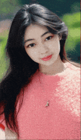 a woman wearing a pink sweater and a necklace with a deer pendant