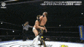 two men are wrestling in a ring with a referee in the background