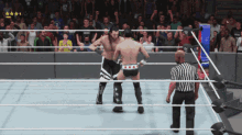 two wrestlers are fighting in a ring with a referee in the background