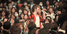a woman singing into a microphone in front of a crowd with a sign that says r.i.p. on it