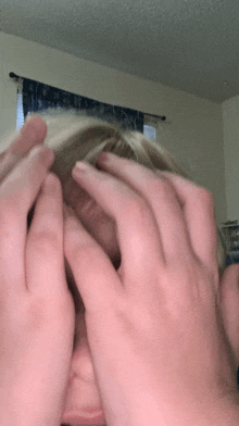 a person is covering their face with their hands