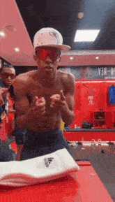 a shirtless man in a locker room with a sign that says y3a-a9