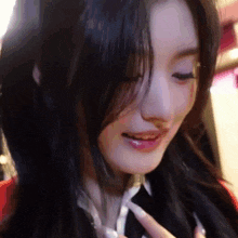 a close up of a woman 's face with her eyes closed and a smile on her face .