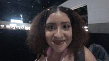 a woman with curly hair and a pink lanyard around her neck