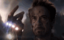 a close up of a man 's face while holding something in his hand .