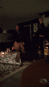 two people are dancing in a dark room with a bottle of dr pepper on the table