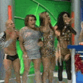 a group of people are standing next to each other on a stage in front of a green screen .