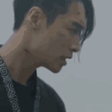 a man with a ponytail is wearing a black shirt and a lanyard .