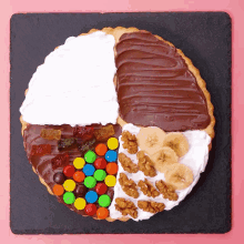 a pie with different toppings including bananas m & m 's nuts and gummy bears
