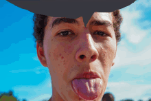 a young man sticking his tongue out with a speech bubble behind him