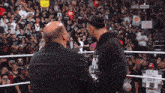 two men in a wrestling ring with a sign that says ' i 'm a real guy '
