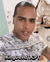 a man in a paisley shirt has the name kingdavidt.cpt on his chest