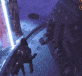 a person is standing in a dark room with a purple light behind them