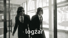 a black and white photo of two men in suits and ties with the word logzar written on the bottom