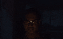 a man wearing glasses is smiling with his eyes closed