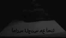 a black and white photo of a man with arabic writing on the bottom