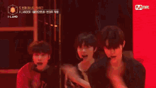 a group of young men are dancing in front of a mnet banner