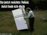 a man is carrying a large refrigerator with the words so jetzt reichts yokai jetzt hab ich dich