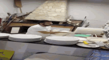 a man in a white apron is standing in front of a table with plates on it