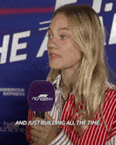 a woman talking into a microphone with the words and just building all the time
