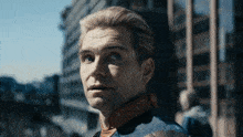 a close up of a man 's face in front of a city skyline