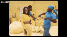 a woman in a yellow top is dancing with two men in blue shirts