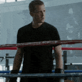 a man wearing boxing gloves stands in a ring