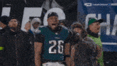 a football player with the number 26 on his jersey is celebrating
