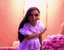 a girl in a purple dress is standing in front of a bunch of pink flowers