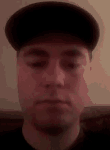 a close up of a man wearing a hat and making a funny face .