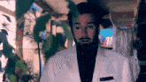 a man with a beard wearing a white jacket and black shirt