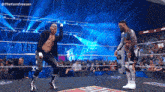two wrestlers are standing in a wrestling ring with a crowd watching and a sign that says yee on it