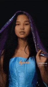 a girl in a blue dress with the word kyra on the front