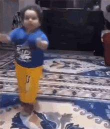 a little boy is dancing on a rug in a living room .