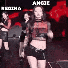 a woman in a crop top and shorts is dancing on stage .