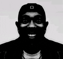 a black and white photo of a man wearing a hat with a smiley face on it