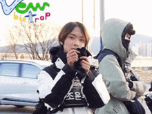 two people standing in front of a sign that says ' vew bie trap '