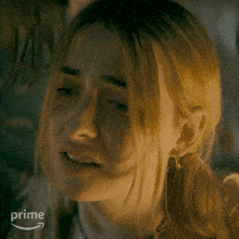 a close up of a woman 's face with a prime logo behind her