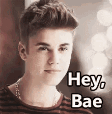 a young man is wearing a striped shirt and a necklace and says `` hey bae '' .