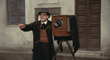 a man in a hat and glasses holds a camera