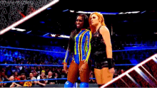 two women are standing in a wrestling ring and one of them is wearing a blue outfit