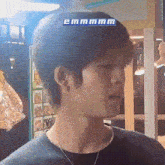 a close up of a man 's face with a blue sticker on his head that says emmmm