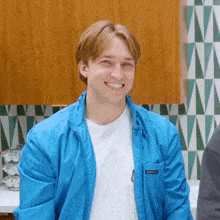 a young man wearing a blue jacket with the word patagonia on the pocket