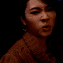 a close up of a woman 's face with her mouth open .