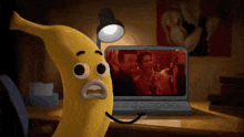 a cartoon banana is looking at a laptop screen