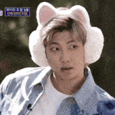 a man wearing ear warmers with cat ears and a blue sign that says s on it