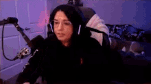 a woman wearing headphones is laying on a man 's back in front of a microphone .