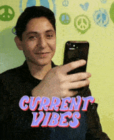 a young man is taking a picture of himself with the words current vibes behind him
